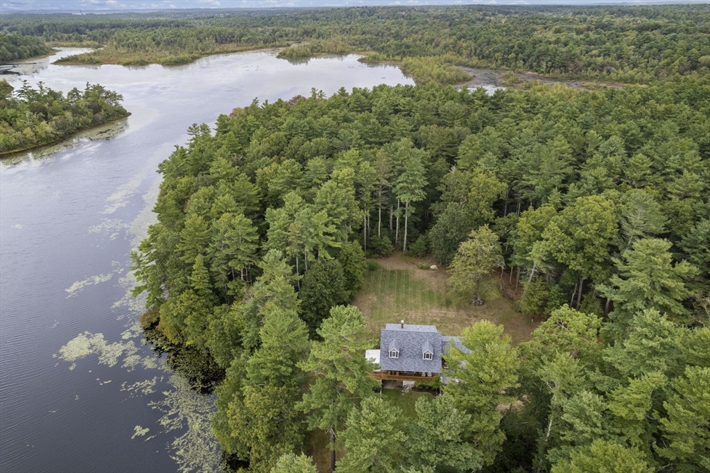 an aerial view of lake residential house with outdoor space and trees around
