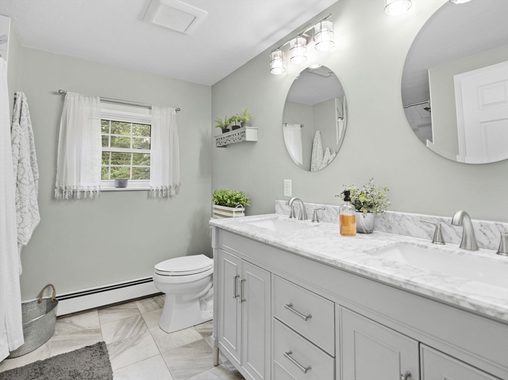 83 Lake Street Acushnet, MA 02743 - Photo 28 of 39 a bathroom with a granite countertop toilet a sink and a mirror