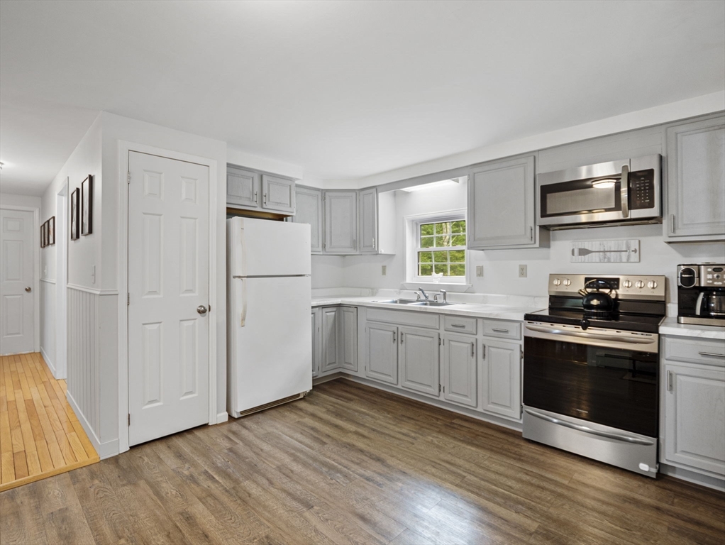 83 Lake Street Acushnet, MA 02743 - Photo 9 of 39 a kitchen with stainless steel appliances white cabinets and wooden floors