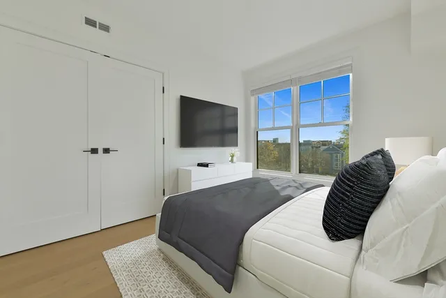 a bedroom with a bed television window and a flat screen television