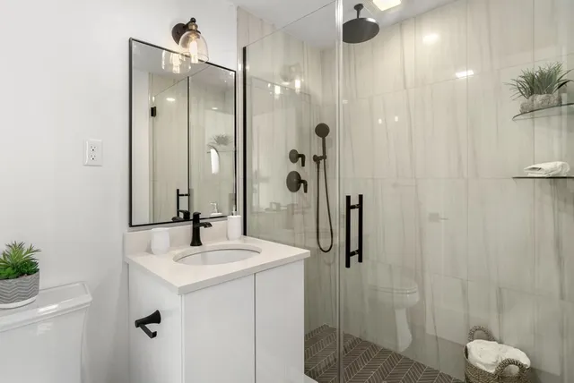 a bathroom with a shower sink and mirror