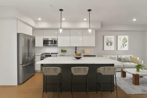 a kitchen with stainless steel appliances granite countertop a sink a stove a refrigerator cabinets and chairs