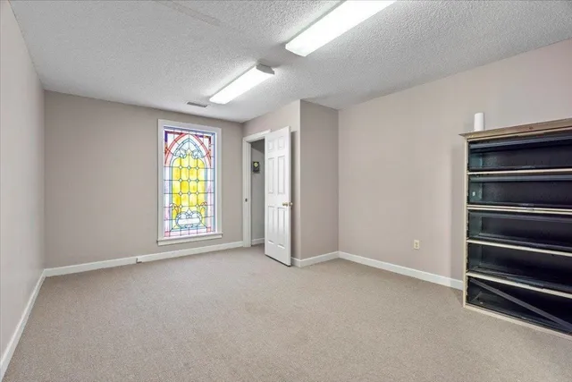 an empty room with a cabinet and mirrors