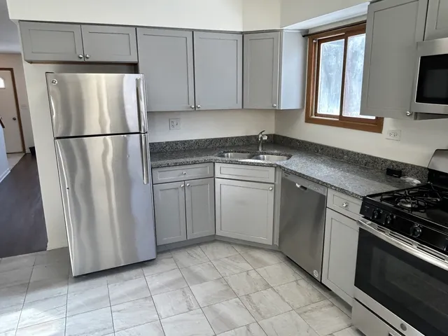 a kitchen with white cabinets stainless steel appliances and a sink