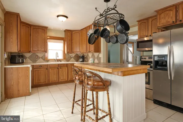 a kitchen with stainless steel appliances granite countertop a sink a stove and a refrigerator
