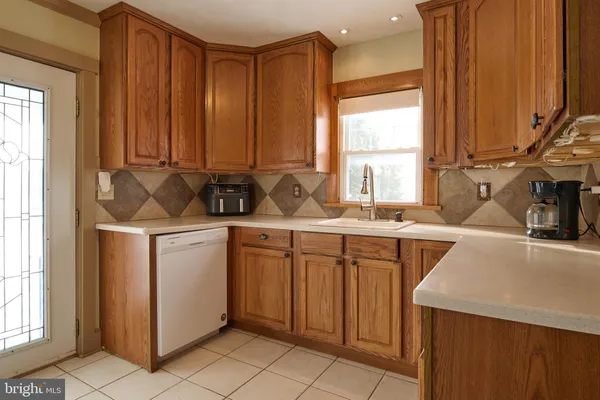 a kitchen with stainless steel appliances a sink window and cabinets
