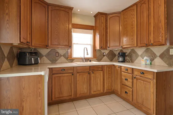 a kitchen with stainless steel appliances a sink cabinets and a window