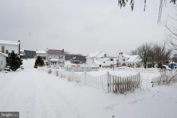 a view of white house with a yard covered in snow