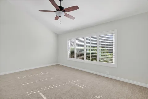 an empty room with a window and a fan