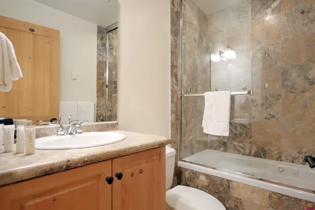 a large kitchen with kitchen island a large counter top stainless steel appliances and cabinets