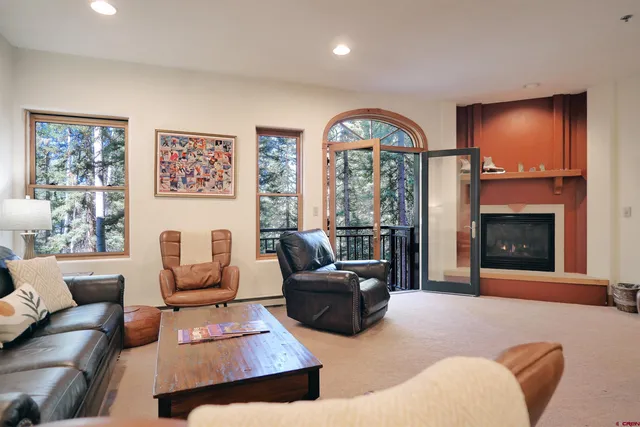 a living room with furniture a flat screen tv and kitchen view