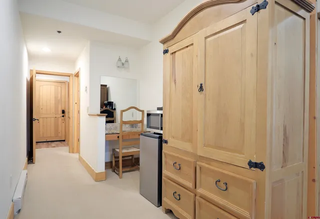 a view of a hallway with wooden floor and glass door