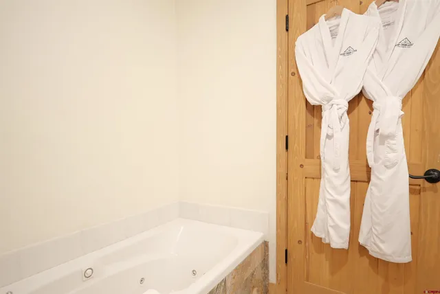 a bedroom with a bed a flat screen tv and dresser