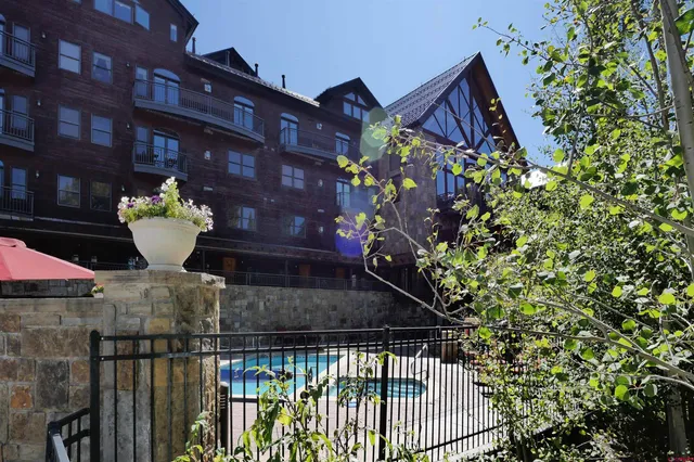 a swimming pool with outdoor seating and trees
