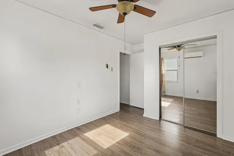 a view of an empty room with a chandelier fan