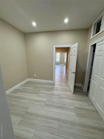 an empty room with wooden floor and entrance