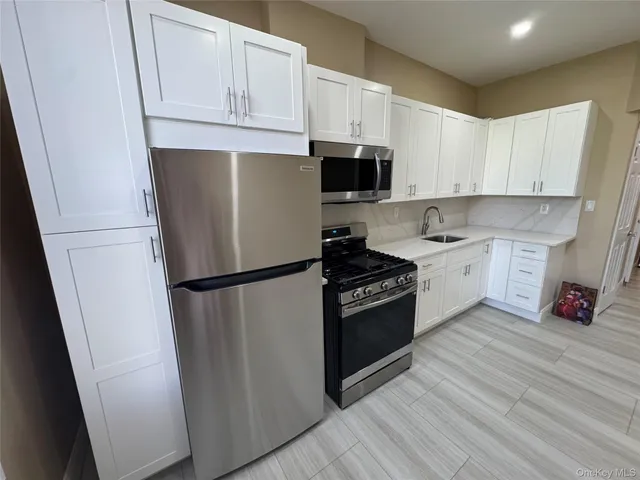 a kitchen with stainless steel appliances a refrigerator sink and cabinets