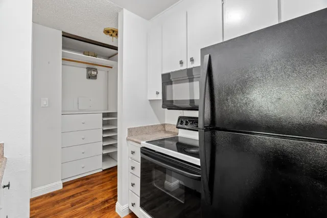 a kitchen with a refrigerator stove and cabinets