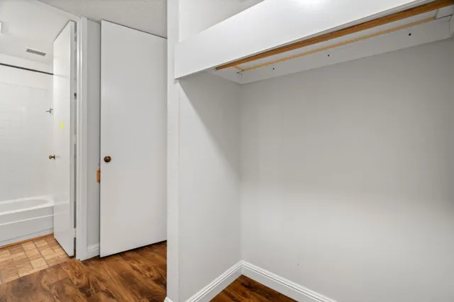 a view of walk in closet with empty racks
