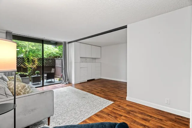 a living room with a bed and glass door
