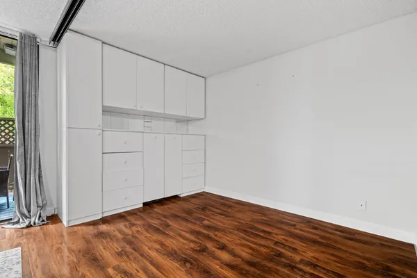 a view of empty room with wooden floor
