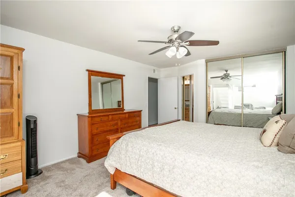 a bedroom with a bed and a ceiling fan