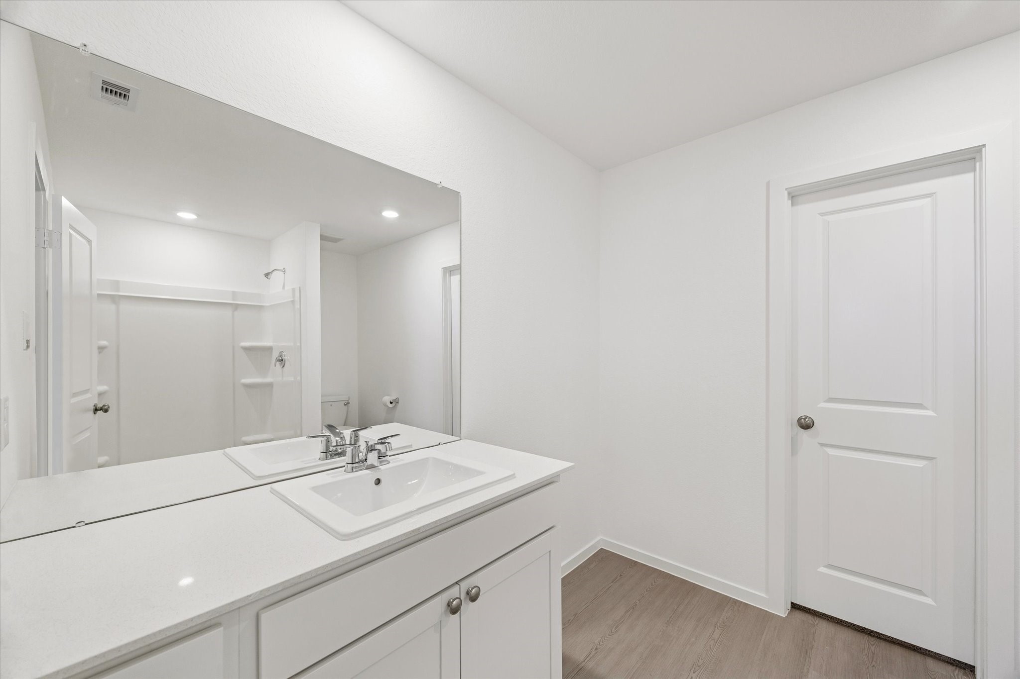 16207 Rustic Prairie Drive Hockley, TX 77447 - Photo 6 of 11 The en-suite bathroom offers a long vanity with generous counter space, recessed lighting, and direct access to a walk-in shower tucked just beyond the mirror reflection.