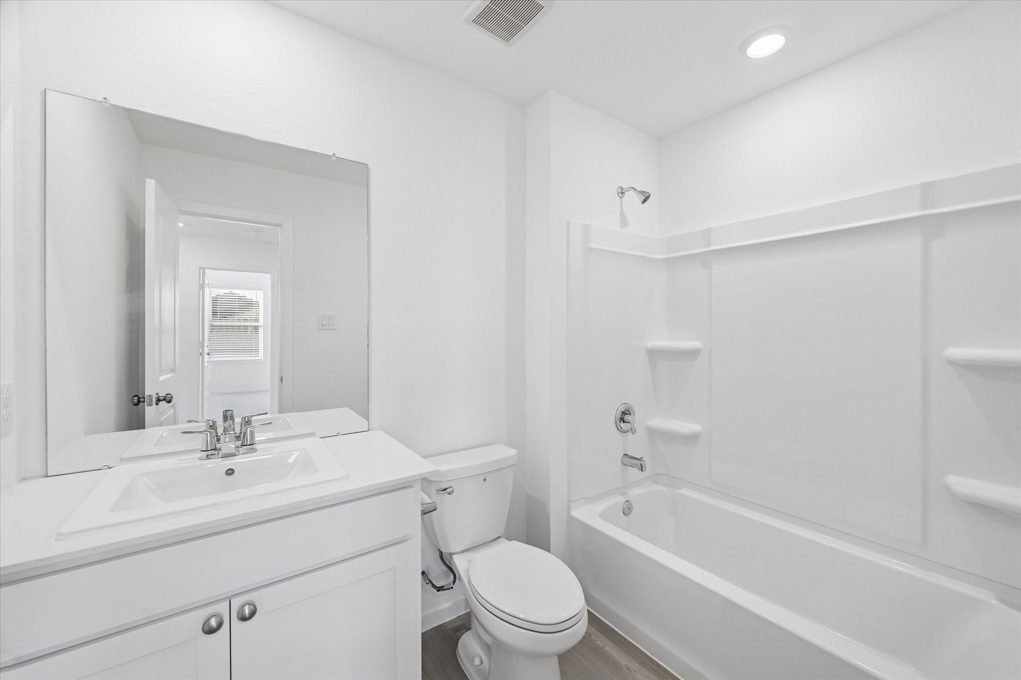 16207 Rustic Prairie Drive Hockley, TX 77447 - Photo 10 of 11 The full guest bathroom includes a sleek vanity with under-sink storage, a large mirror, and a tub/shower combo with built-in shelving for convenience.