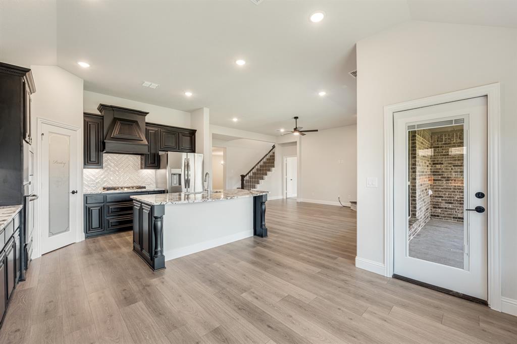 960 Imperial Eagle Road Alvarado, TX 76009 - Photo 21 of 40 a kitchen with stainless steel appliances kitchen island granite countertop a stove and a refrigerator