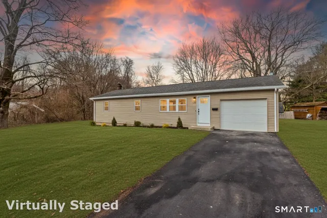 a view of a white house with a yard and garage