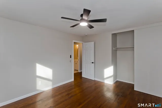 a bedroom with a large bed and a ceiling fan