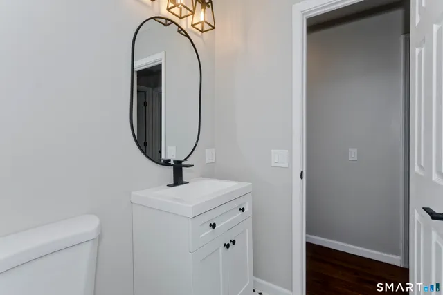 a bathroom with a sink a toilet and a mirror
