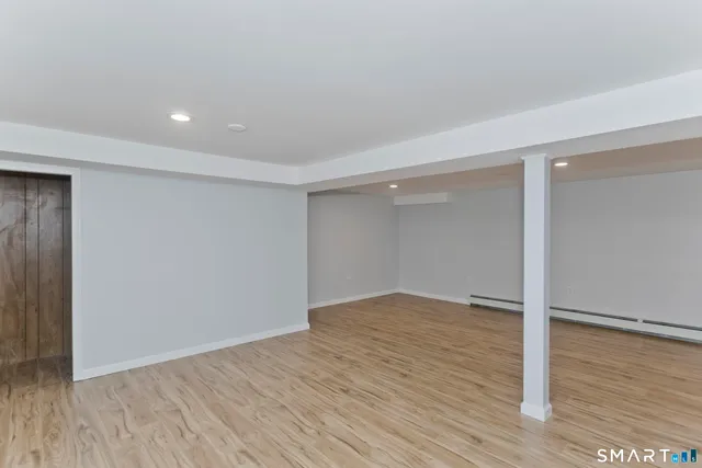 a view of an empty room with wooden floor