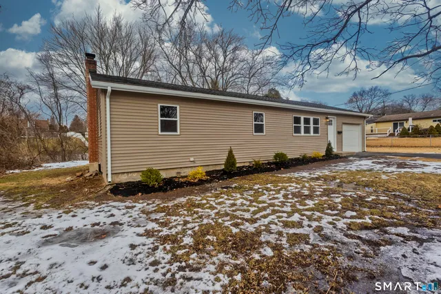 a backyard of a house with large trees and wooden fence