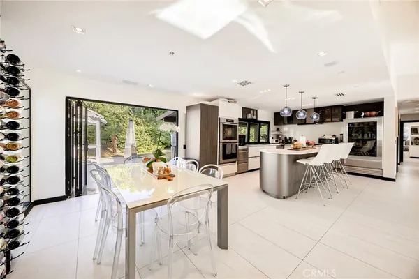 a kitchen with a refrigerator a flat screen tv and a fireplace