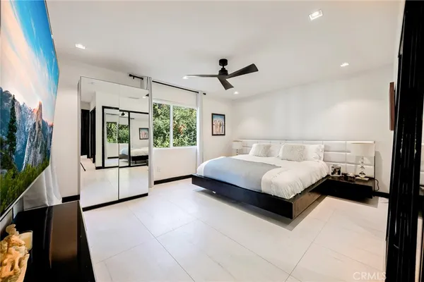 a bedroom with a large bed and a large window