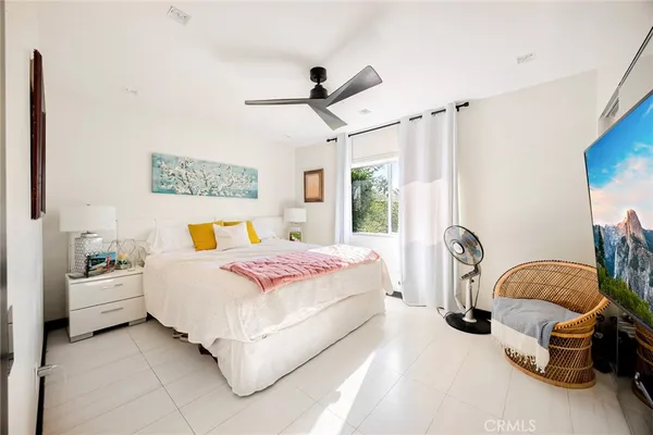 a bedroom with a large bed and a flat tv screen