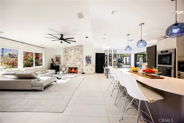 a living room with furniture a flat screen tv and a large window