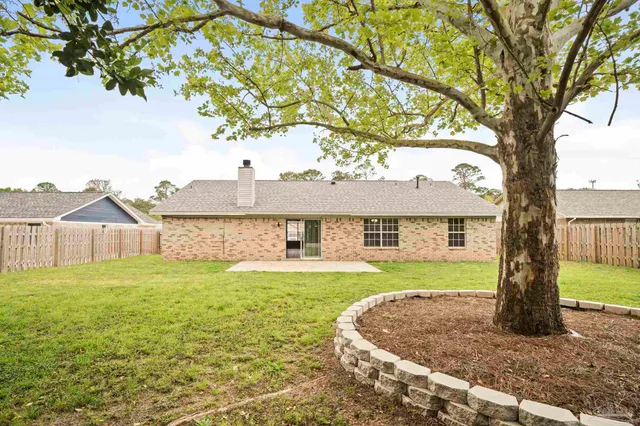 a front view of a house with a garden and tree
