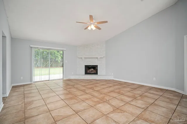 a view of an empty room with a window and a fireplace