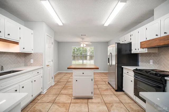 a kitchen with stainless steel appliances kitchen island granite countertop a stove a sink and a refrigerator