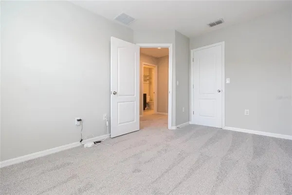 an empty room with closet and wooden door