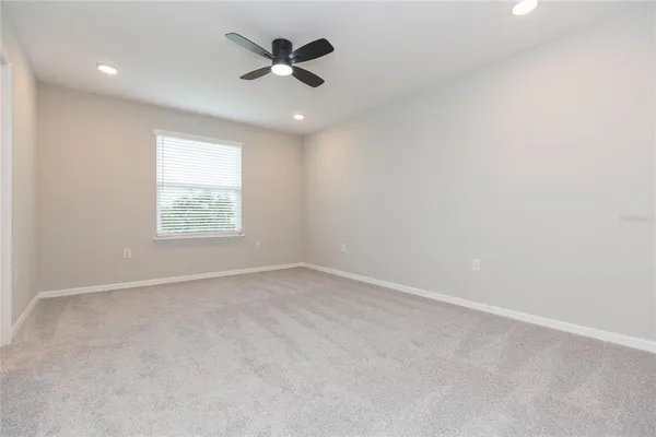 an empty room with a window and a fan
