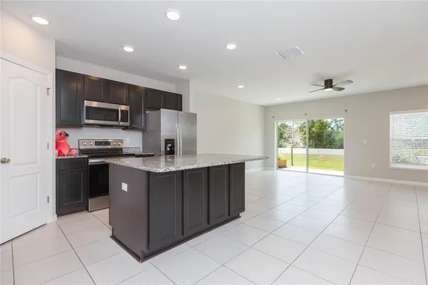 a kitchen with stainless steel appliances granite countertop a refrigerator and a stove top oven