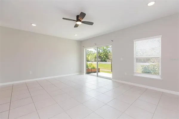 an empty room with fan and windows