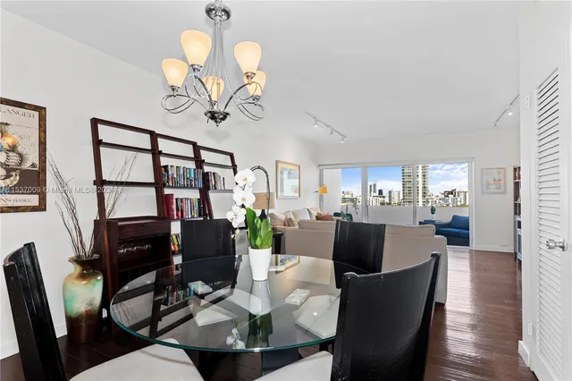 a view of a dining room with furniture a chandelier and wooden floor