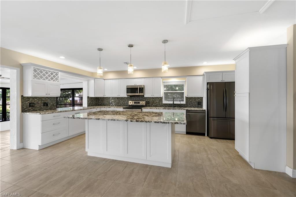 3461 Lakeview Drive Naples, FL 34112 - Photo 12 of 32 a kitchen with stainless steel appliances granite countertop a refrigerator a sink a stove a microwave and white cabinets