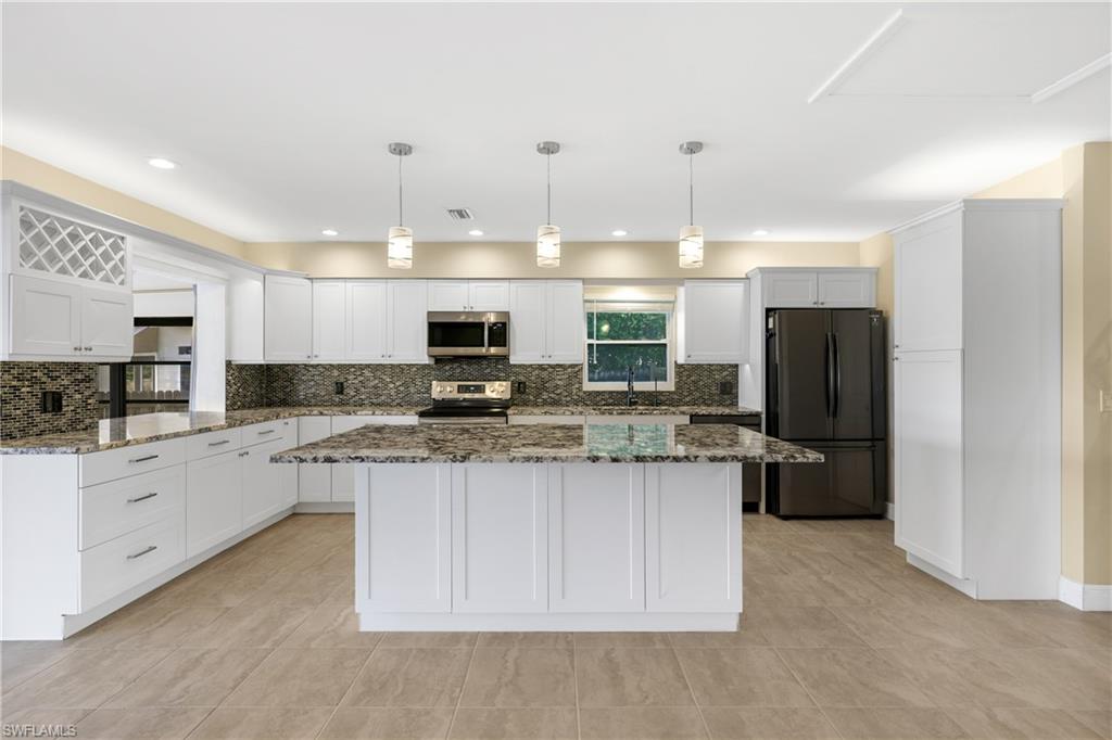 3461 Lakeview Drive Naples, FL 34112 - Photo 13 of 32 a kitchen with stainless steel appliances a refrigerator a sink a stove a microwave and island