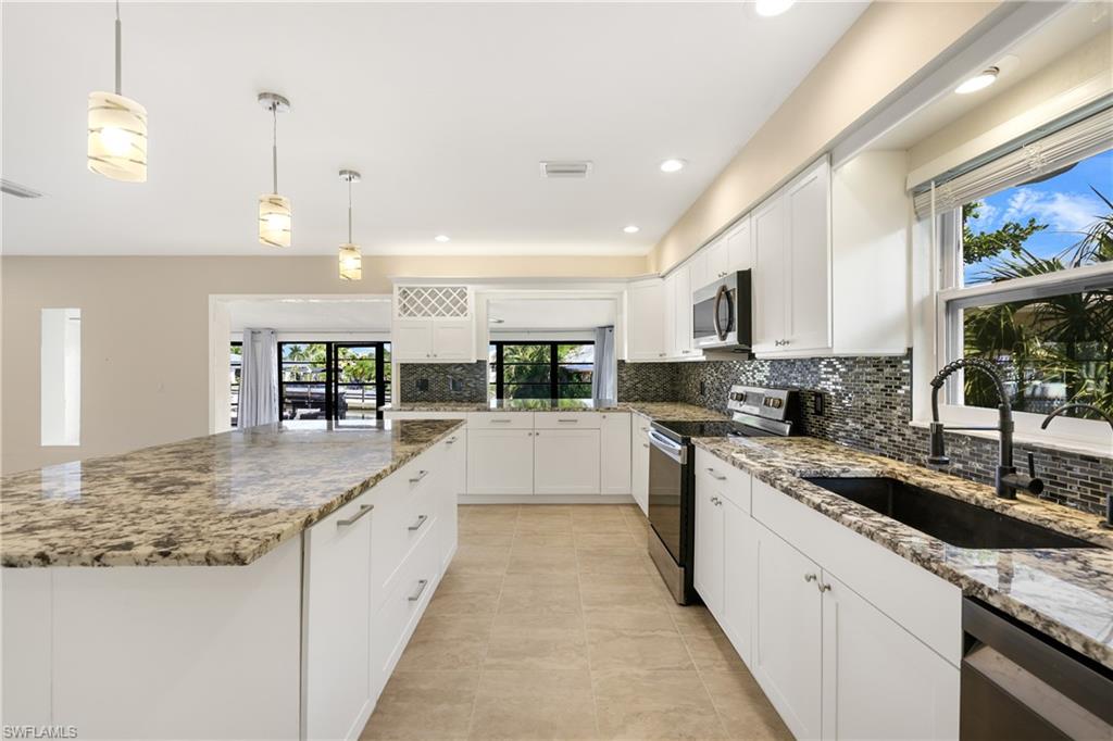 3461 Lakeview Drive Naples, FL 34112 - Photo 16 of 32 a large kitchen with granite countertop a large counter top cabinets and stainless steel appliances