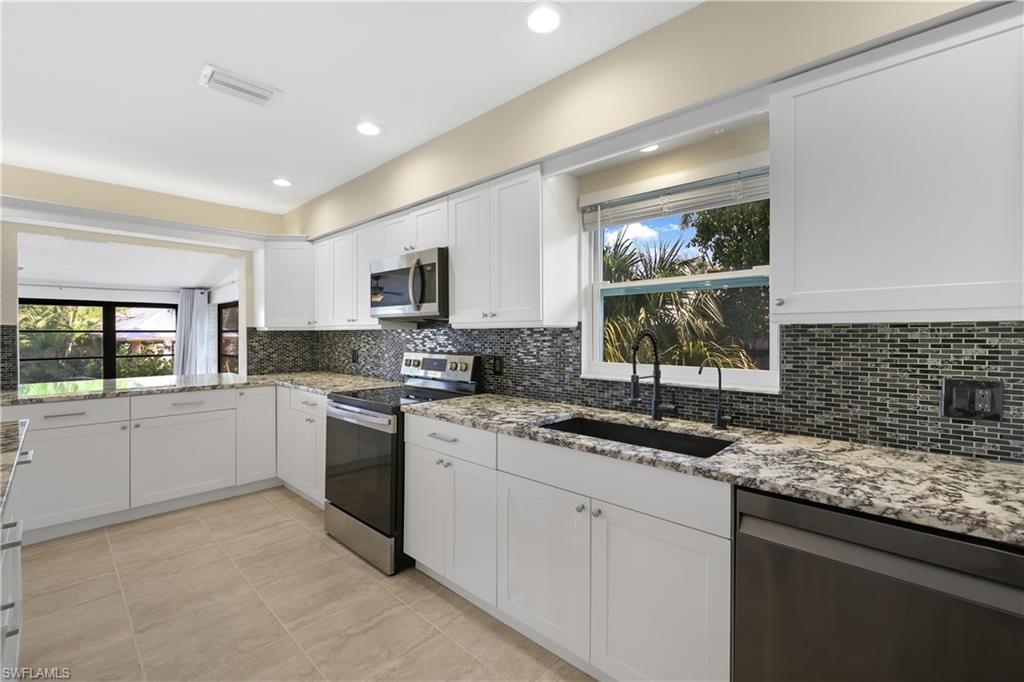 3461 Lakeview Drive Naples, FL 34112 - Photo 17 of 32 a kitchen that has a sink and a stove in it